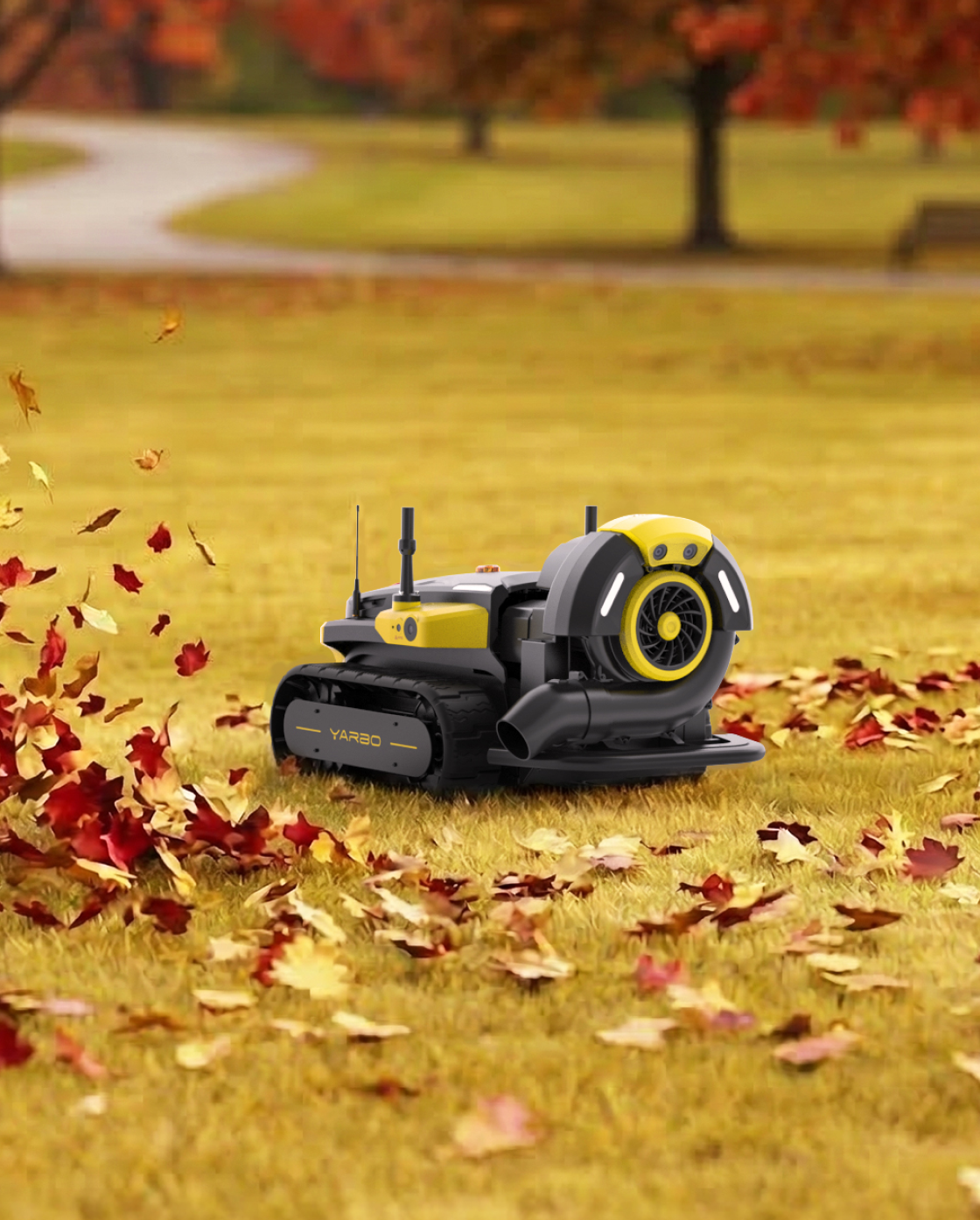 Black and yellow robotic lawn mower by Yarbo with tank treads, blower attachment, and autumn leaves on grass.