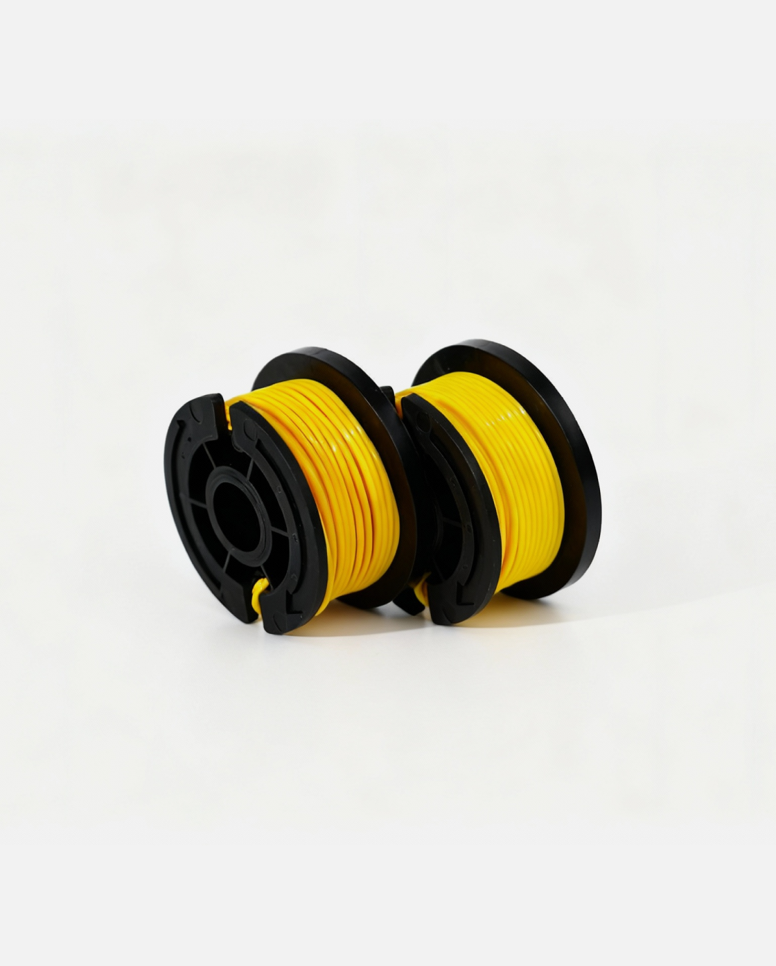 Yellow trimmer line spool with black plastic housing, side view, two units on white background