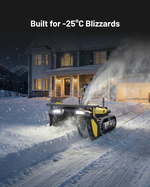 Yellow and black tracked snow blower by Yarbo clearing driveway in heavy snow at night, front view with illuminated headlights.